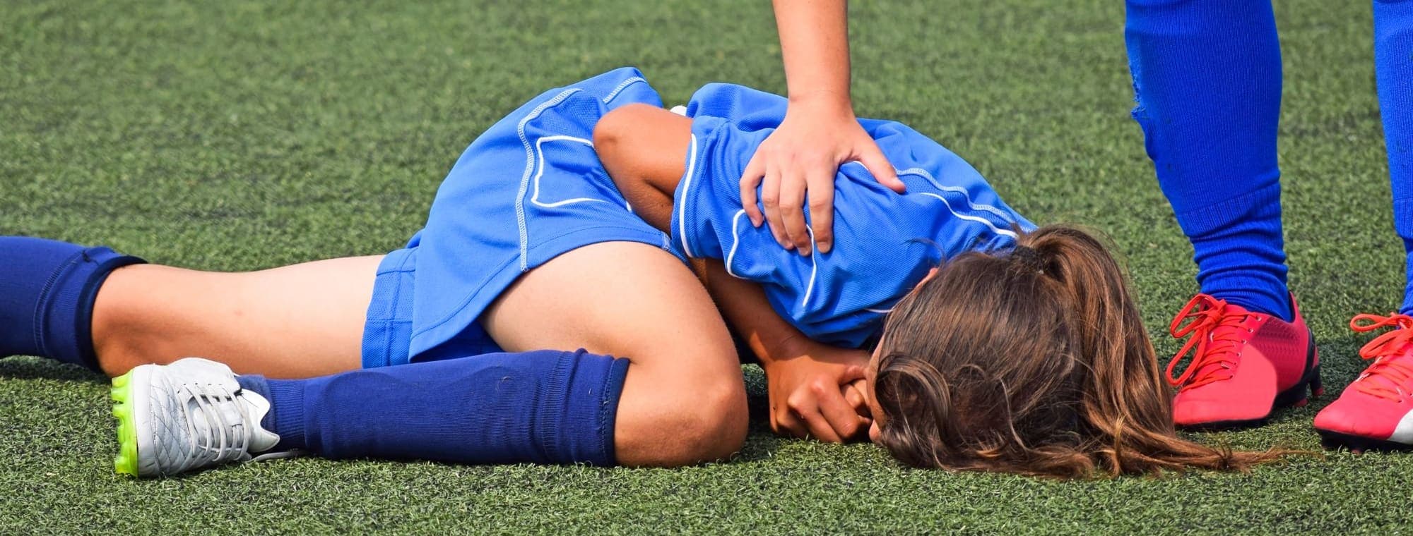 A player down on the pitch being attended to
